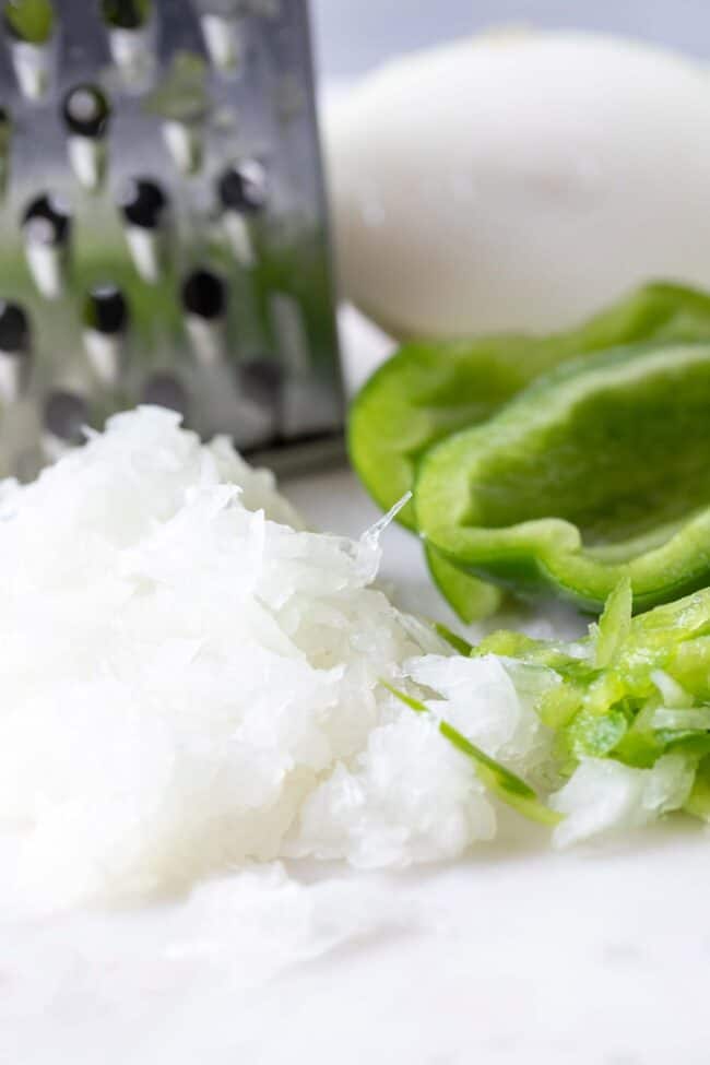 A silver cheese grated with grated onion and bell pepper.