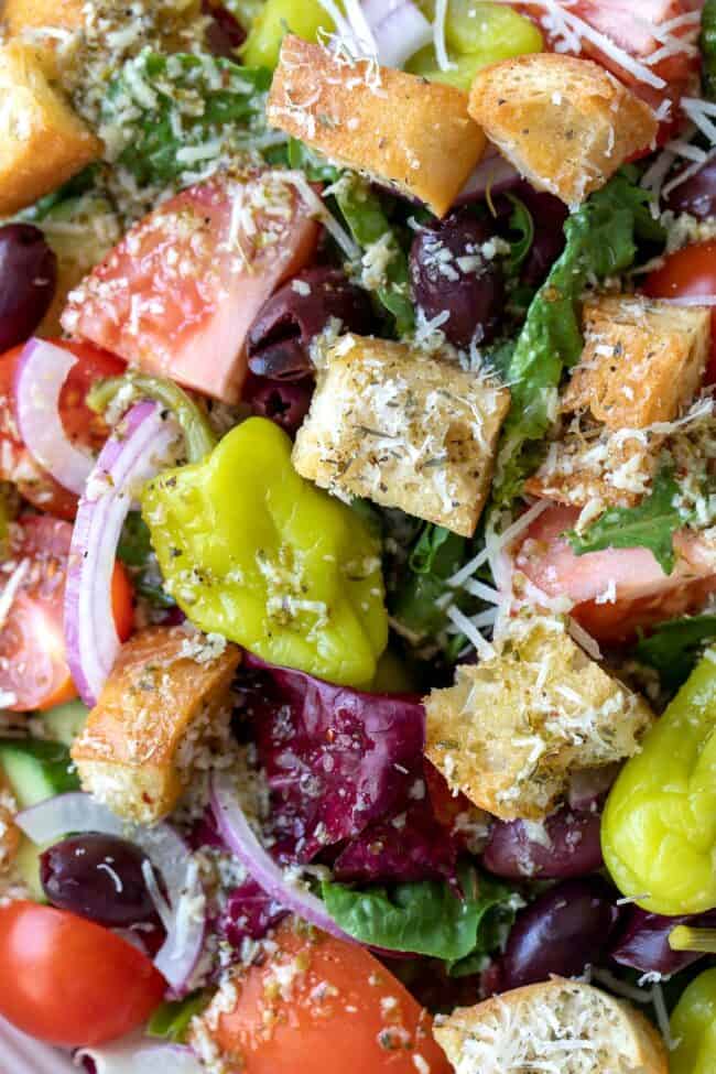 A white bowl of tossed vegetables with croutons.