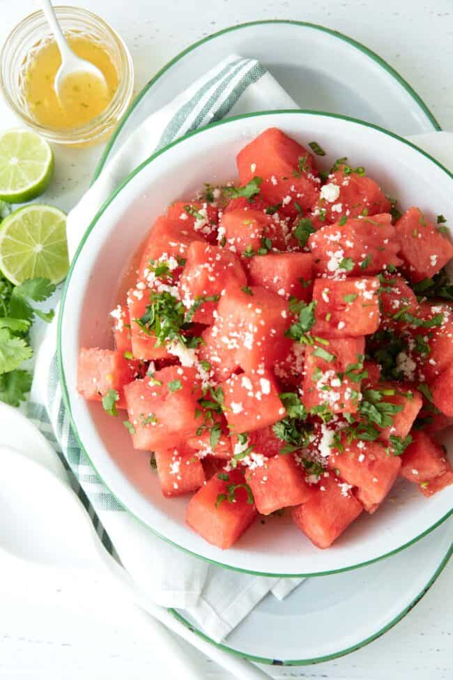 white bowl filled with cubed pieces of watermelon for watermelon salad.