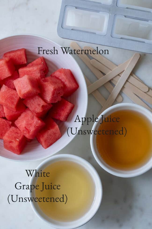 White bowls with watermelon chunks, apple juice and white grape juice.