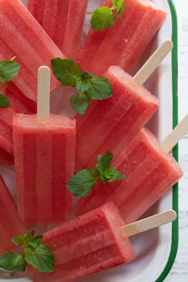 A white bowl filled with watermelon popsicles.