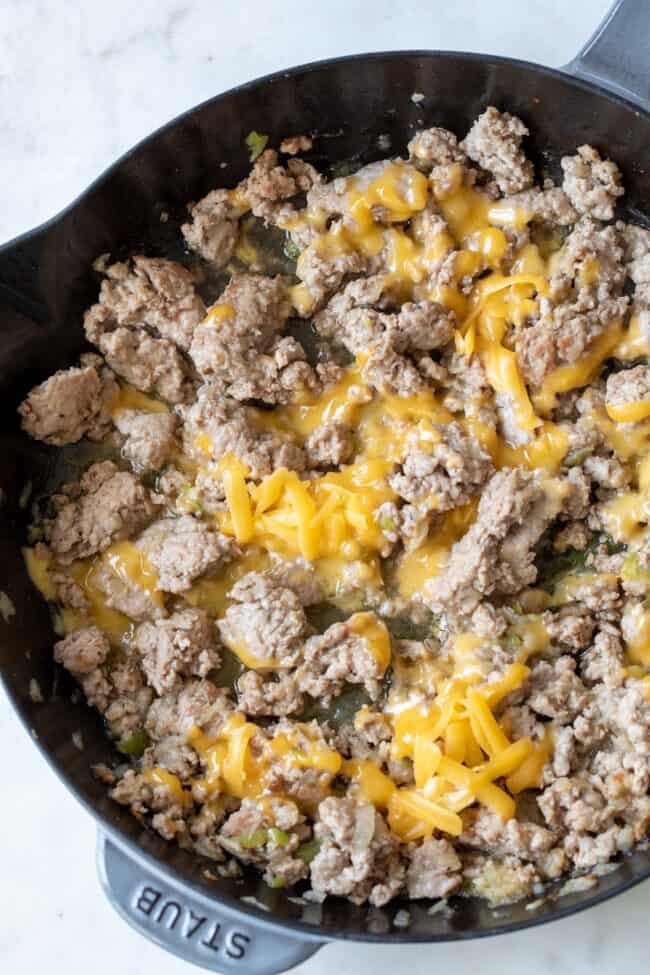 cast iron skillet cooking ground turkey with melted cheese