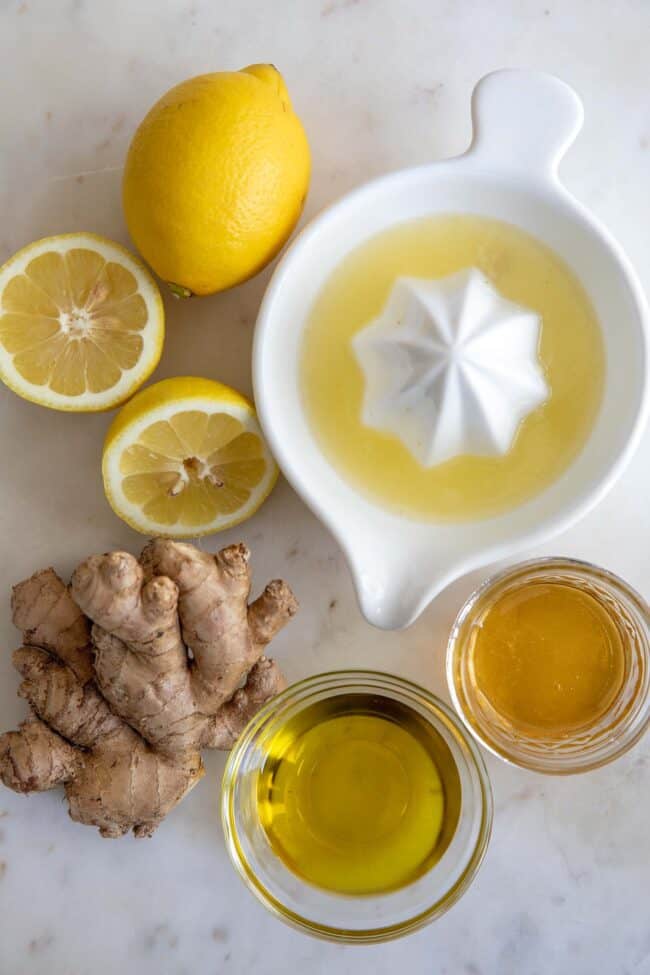 cut lemons, lemon juice and pieces of ginger for salad dressing
