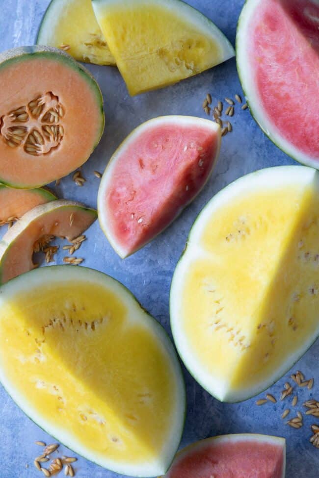 Large cut wedges of yellow watermelon, red watermelon and cantaloupe