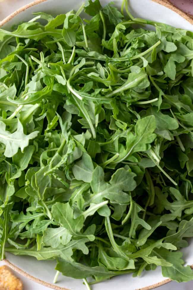 A white bowl of leafy greens