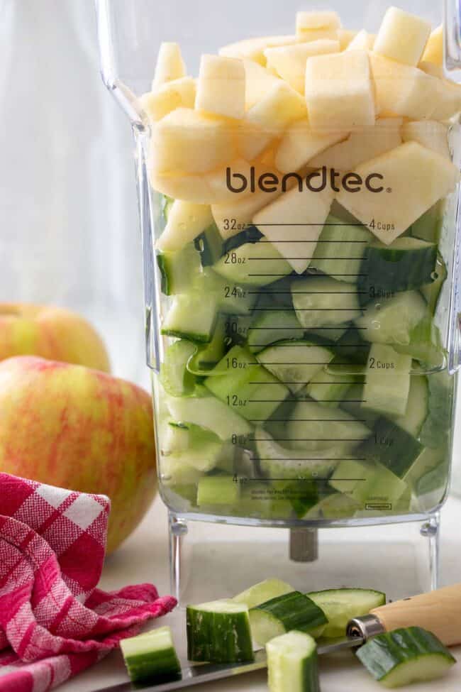 A blender container filled with chopped fruit.