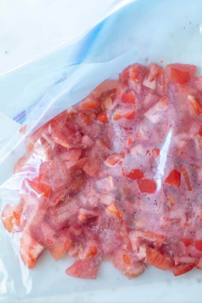 A clear plastic bag filled with chopped fruit