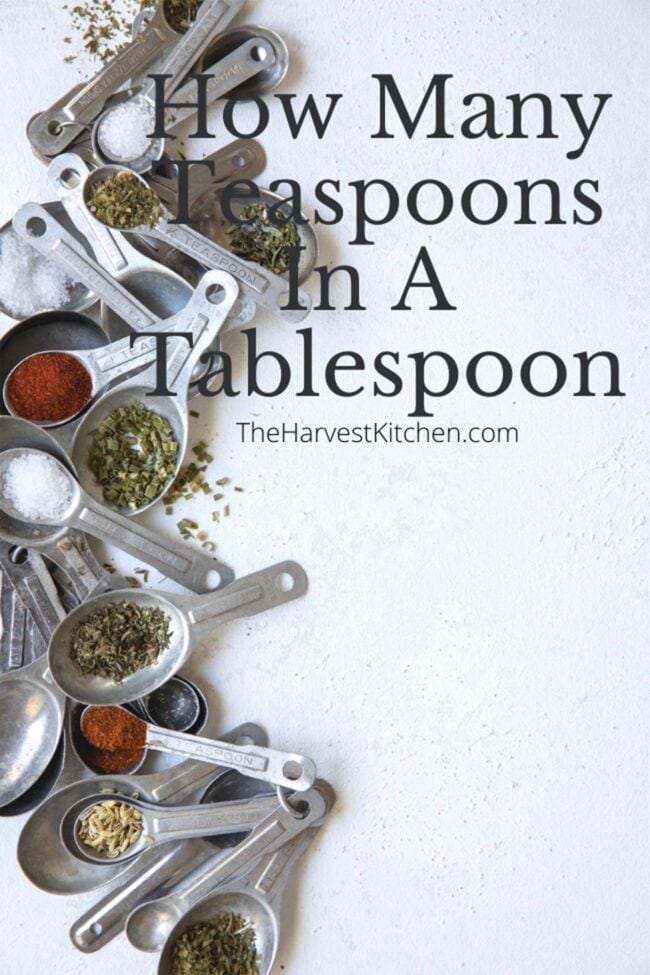 to represent how many teaspoons in a tablespoon there are several different sizes of measuring spoons scattered and filled with different herbs and spices