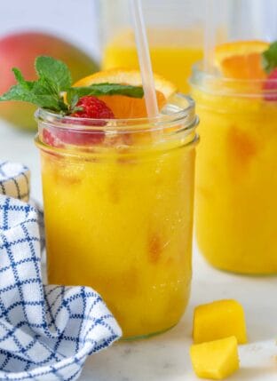 Two glasses filled with mango juice.
