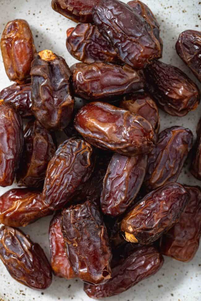 A pile of fresh dates on a plate.