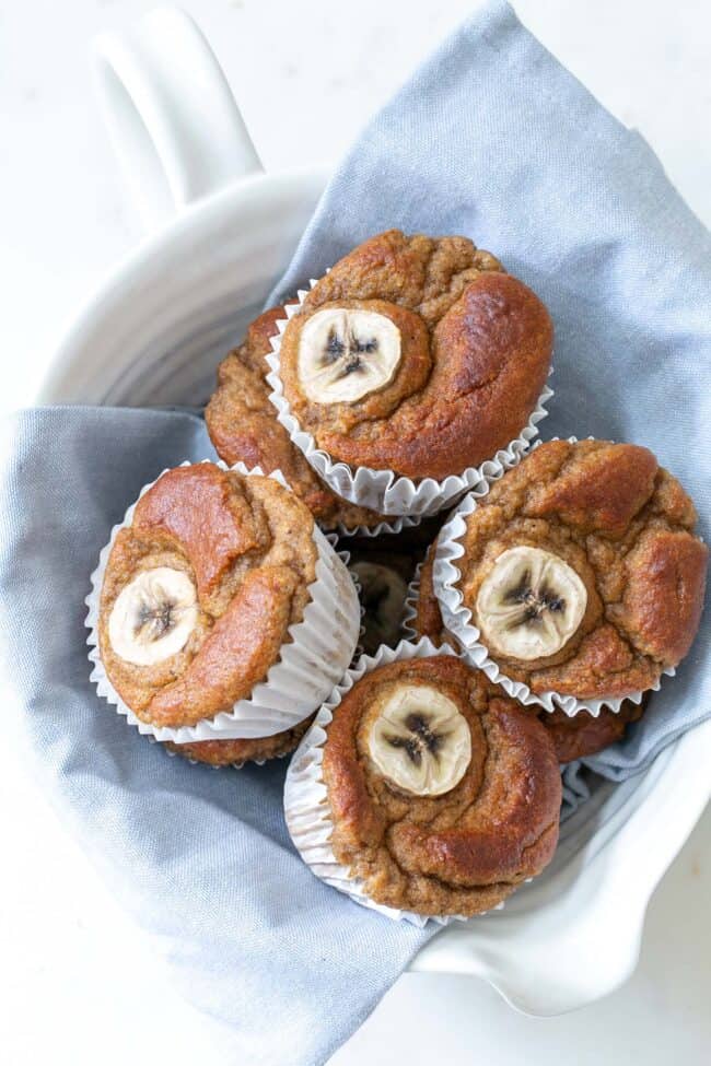 A white bowl filled with banana bread muffins.