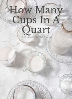 7 clear glass measuring cups and a clear glass quart bottle filled with almond milk