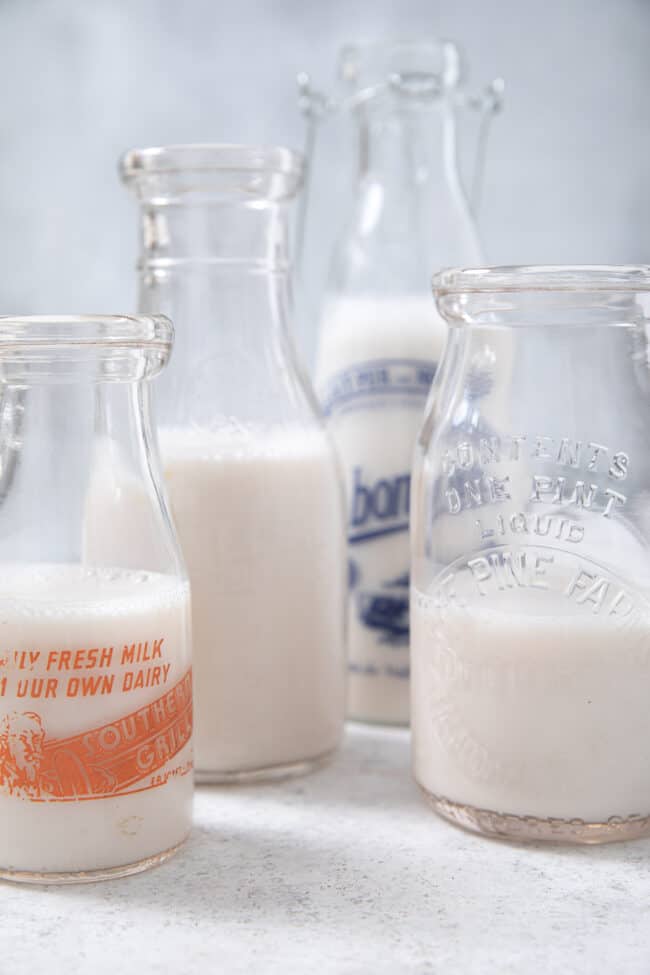 Vintage pint milk bottles filled with almond milk to measure how many ounces in a pint