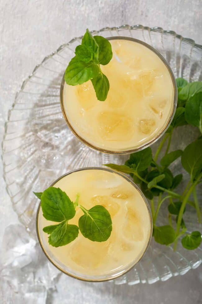 Two drinking glasses filled with fresh passion fruit juice