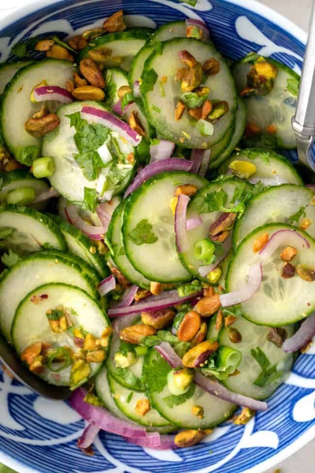 Blue and white bowl filled with cucumber Asian salad