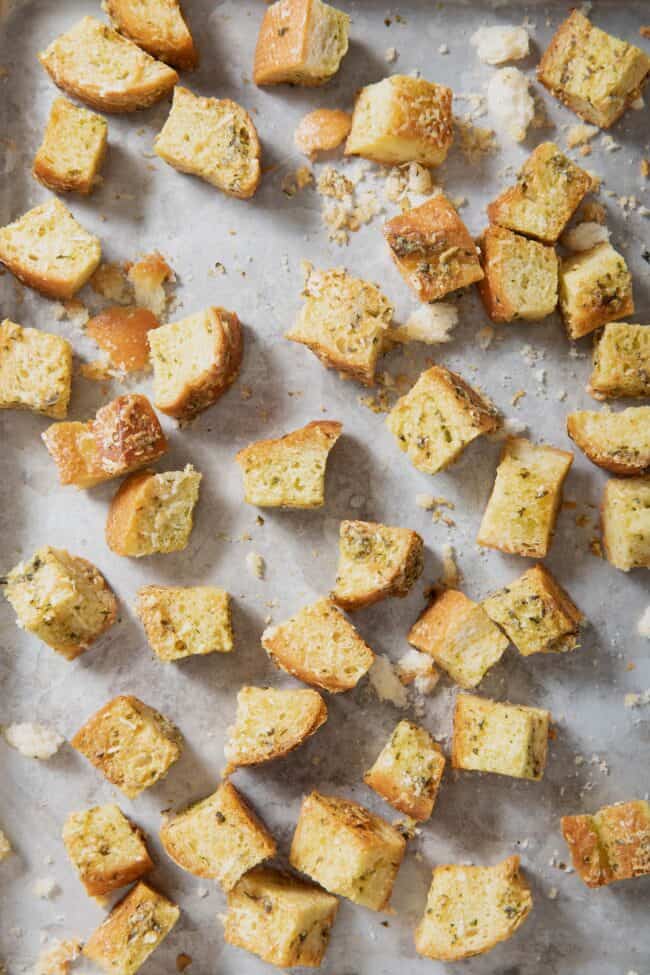 An aluminum baking sheet filled with Italian croutons.