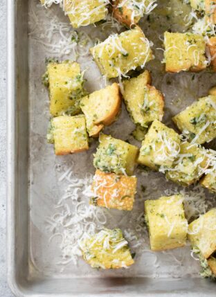 aluminum cookie sheet filled with basil pesto croutons.