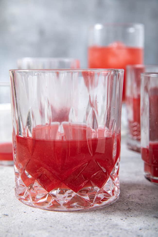 Several drinking glasses filled with red beet juice.