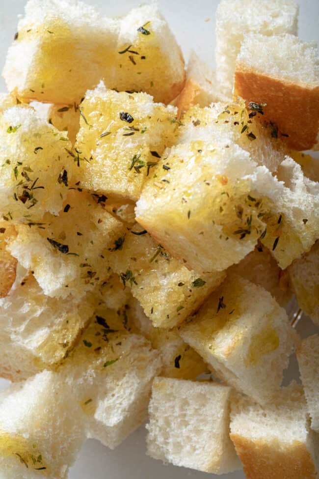 Bread cut into cubes and tossed with melted butter and seasoning for how to make croutons