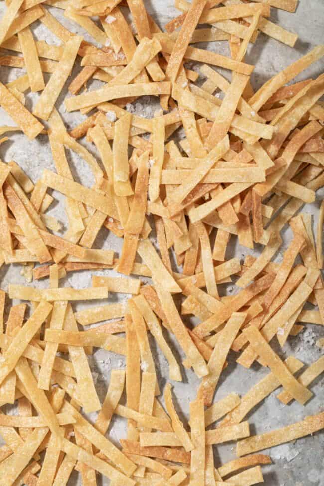 A cookie sheet filled with baked tortilla strips for salad