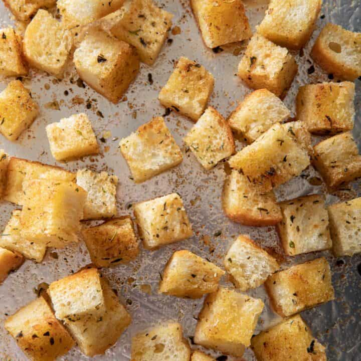 A cookie sheet filled with homemade croutons