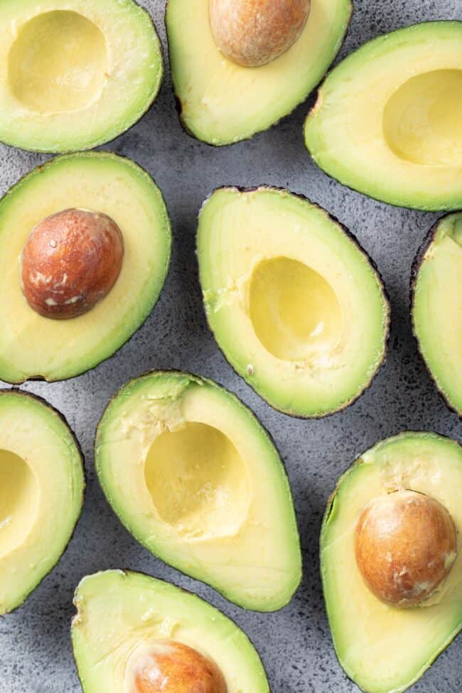 Several avocados sliced in half for avocado fruit or vegetable