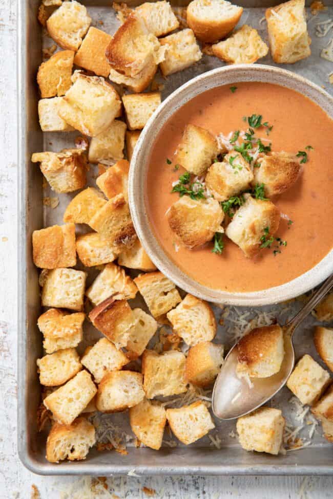 A baking sheet filled with Parmesan cheese croutons.