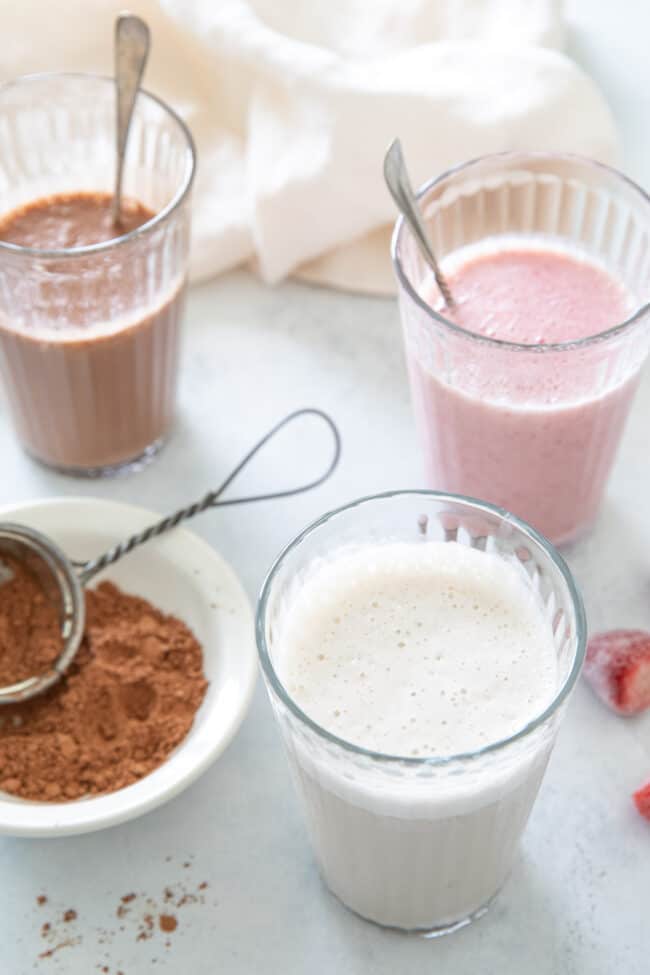 Three clear glasses filled with dairy free banana milk. 