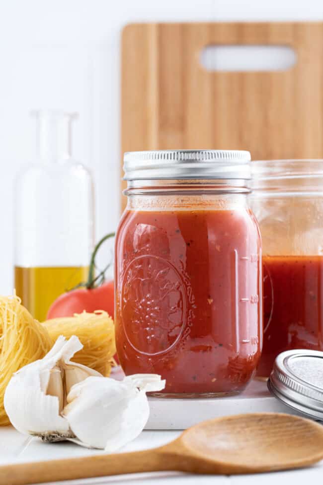 A clear glass mason jar filled with a tomato puree.