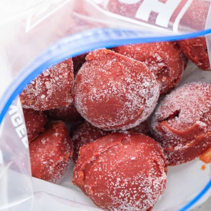A freezer bag filled with balls of frozen tomato paste