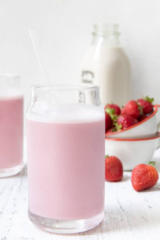 Two clear glasses filled with strawberry milk