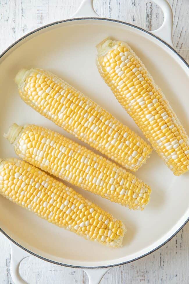 Fresh vegetables in a white pot filled with water.