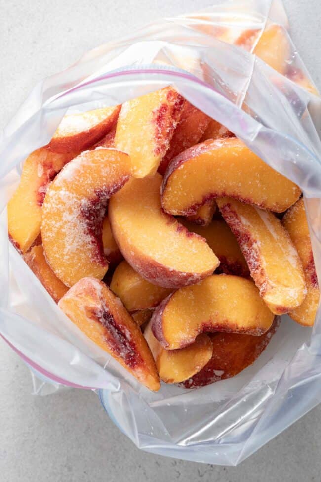 A freezer bag filled with frozen peaches.