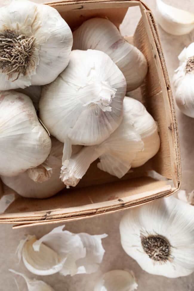 A small wooden box filled with garlic bulbs - for best garlic substitutes.