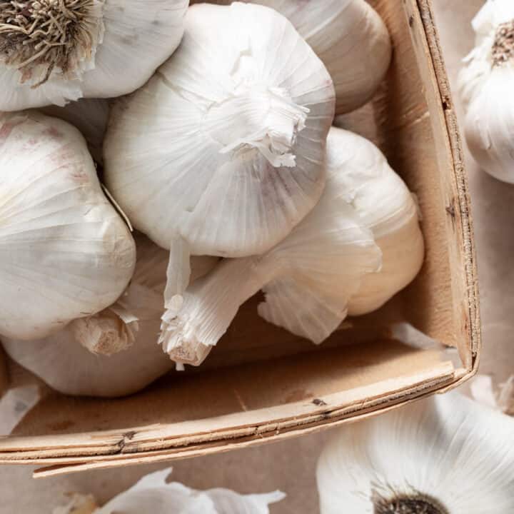 A small wood box filled with garlic bulbs.