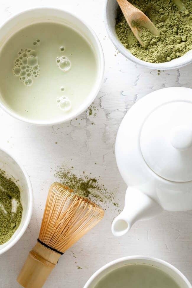 White cups filled with matcha latte, matcha ice cream and dried matcha powder with a wooden spoon (for how many ounces in a tablespoon - tbsp to oz)