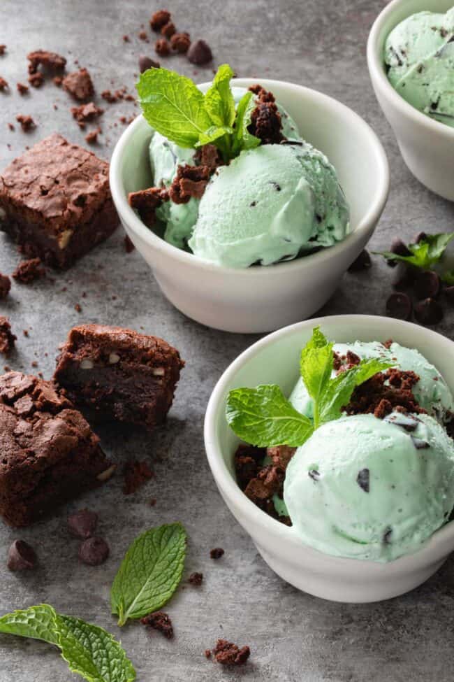 Three small white bowls filled with mint chocolate chip ice cream with brownies crumbled on top - for how many pints in a gallon.