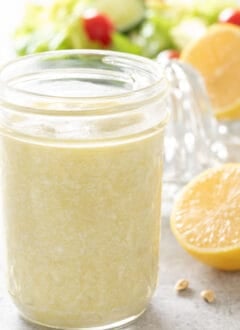 A clear glass mason jar filled with Creamy Gorgonzola Dressing.