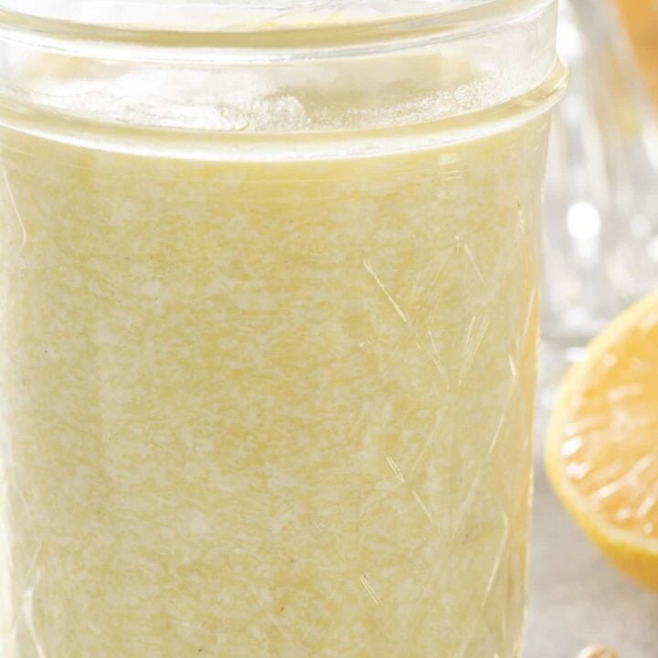 A clear glass mason jar filled with Creamy Gorgonzola Dressing.