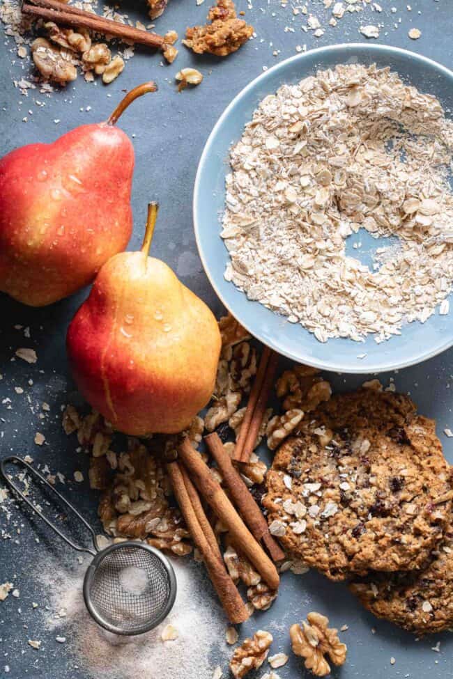 A small blue bowl filled with raw oatmeal next to cinnamon sticks, pears and walnuts for how many tablespoons in 2/3 cup.