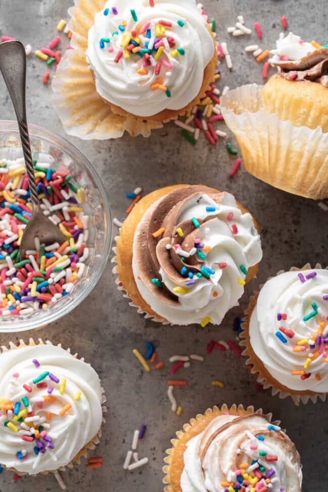 6 cupcakes with white frosting and funfetti sprinkles.