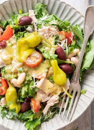A grey plate filled with Mediterranean Tuna Salad (tossed with cherry tomatoes, cannellini beans and kalamata olives)