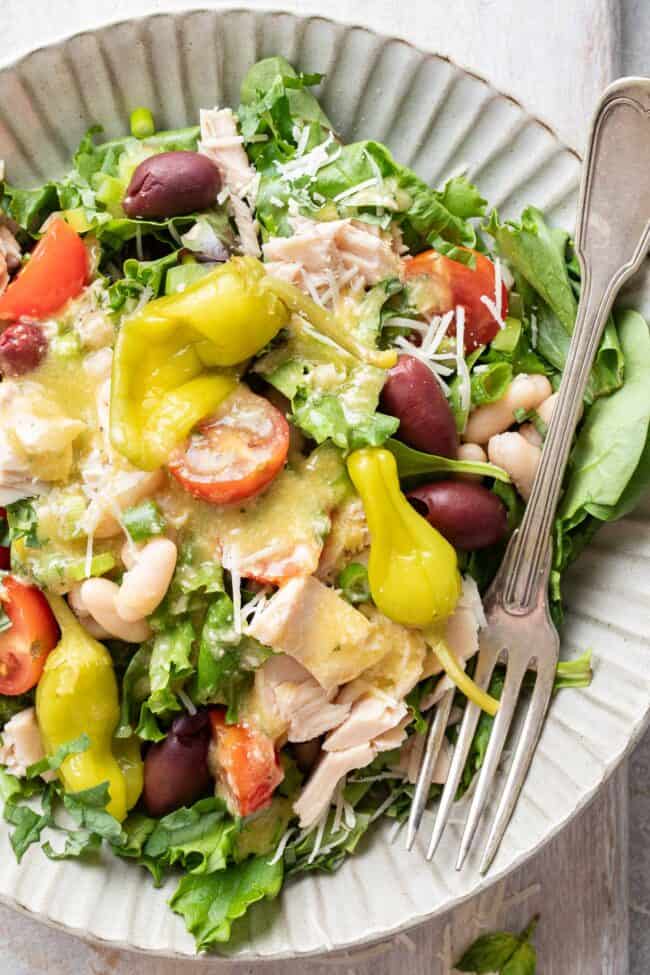 A grey plate filled with Mediterranean Tuna Salad (tossed with cherry tomatoes, cannellini beans and kalamata olives)