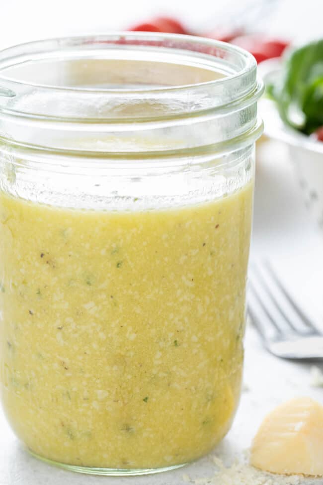 A clear glass mason jar filled with Parmesan Vinaigrette dressing.