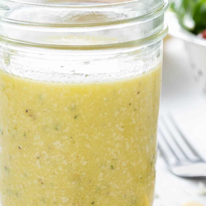 A clear glass mason jar filled with Parmesan Vinaigrette dressing.