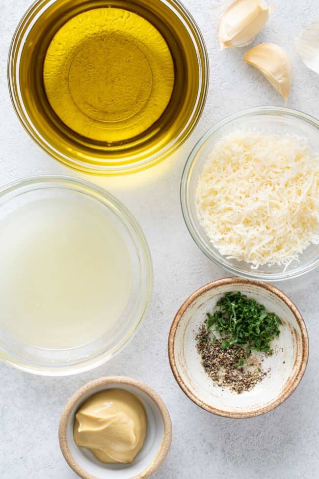 5 small bowls; one filled with olive oil, one filled with lemon juice, one filled with parmesan cheese, Dijon mustard and freshly cracked black pepper.