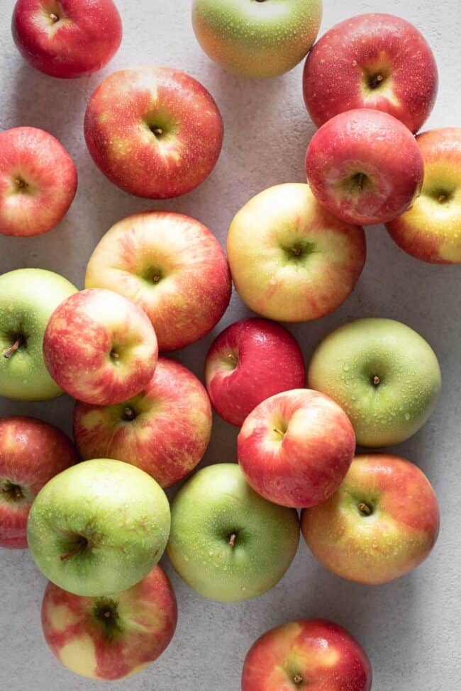 An assortment of different types of apples scattered on a counter for best apples for apple crisp.