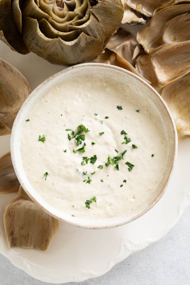 A white bowl filled with a creamy white dip.