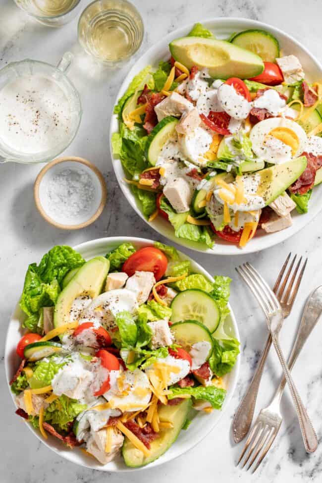 Two white bowls filled with chopped salad.