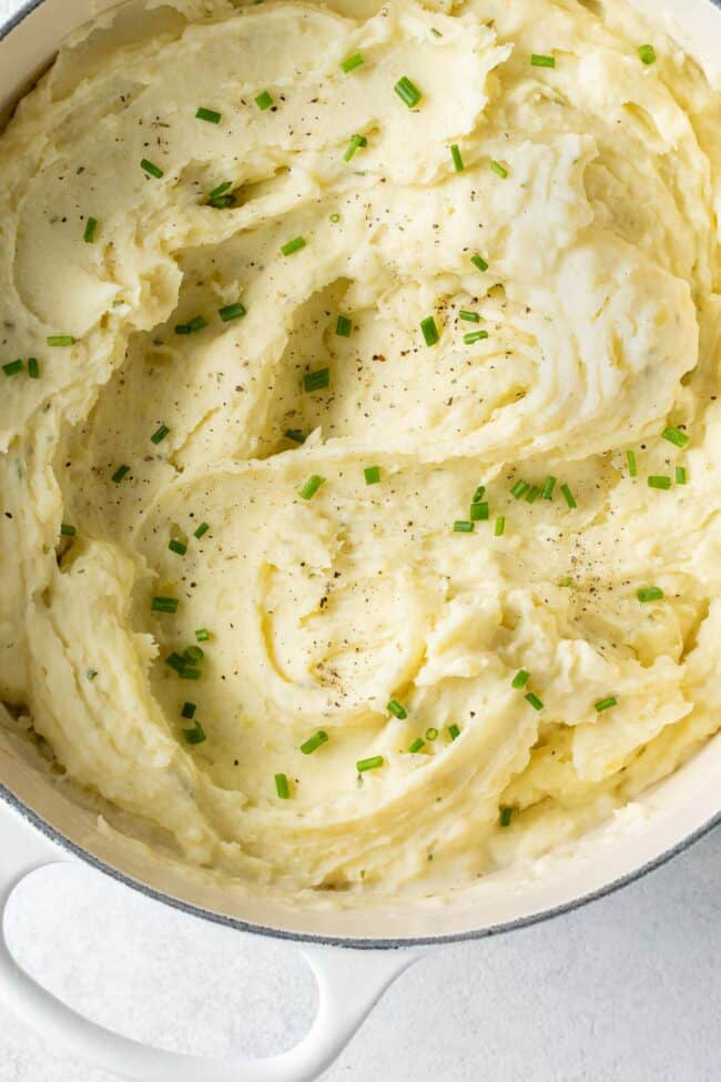 A white pot filled with mashed vegetables.